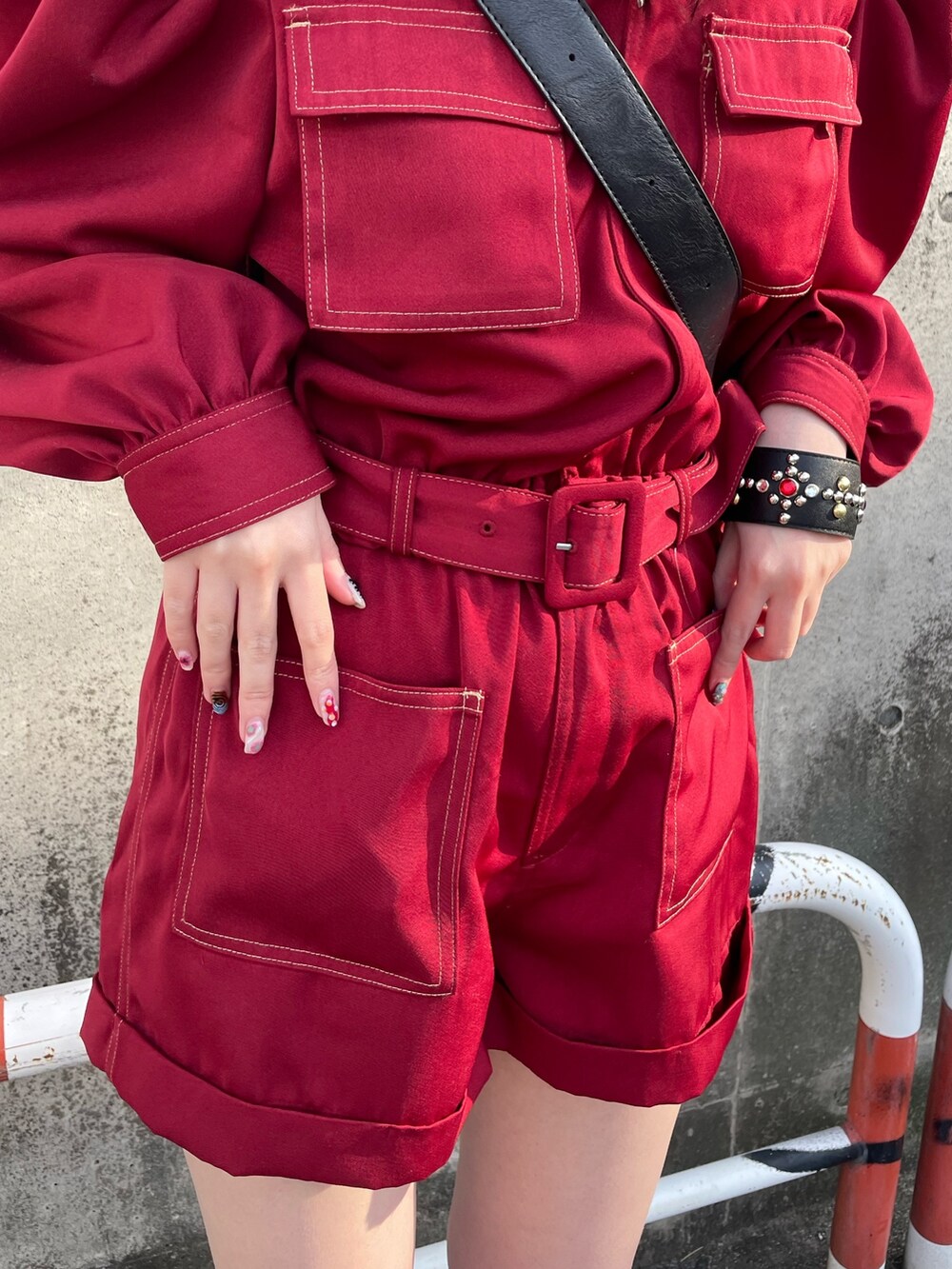 ブラック系のサンダル、レッド系のつなぎ/オールインワン、ブラック系のショルダーバッグを着用したレディースの春コーディネートの6枚目の写真