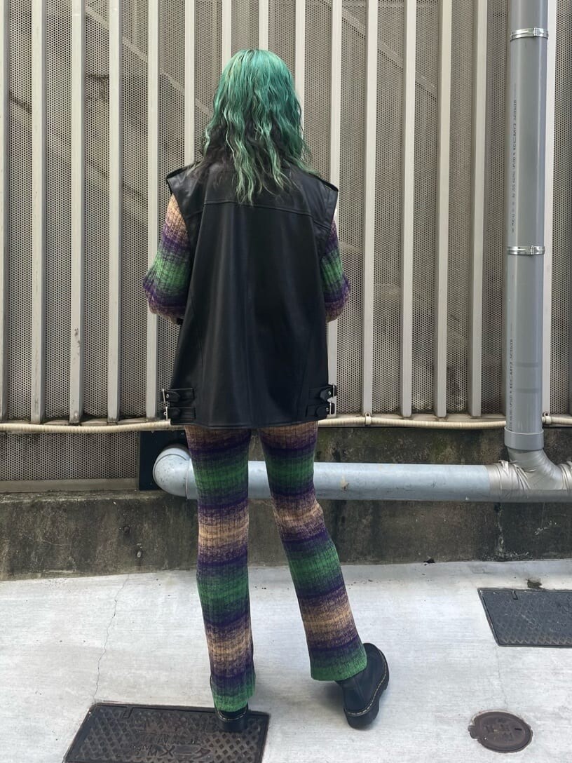 ブラック系のライダースジャケット、グリーン系のその他パンツ、ブラック系のハンドバッグを着用したレディースの秋コーディネートの3枚目の写真