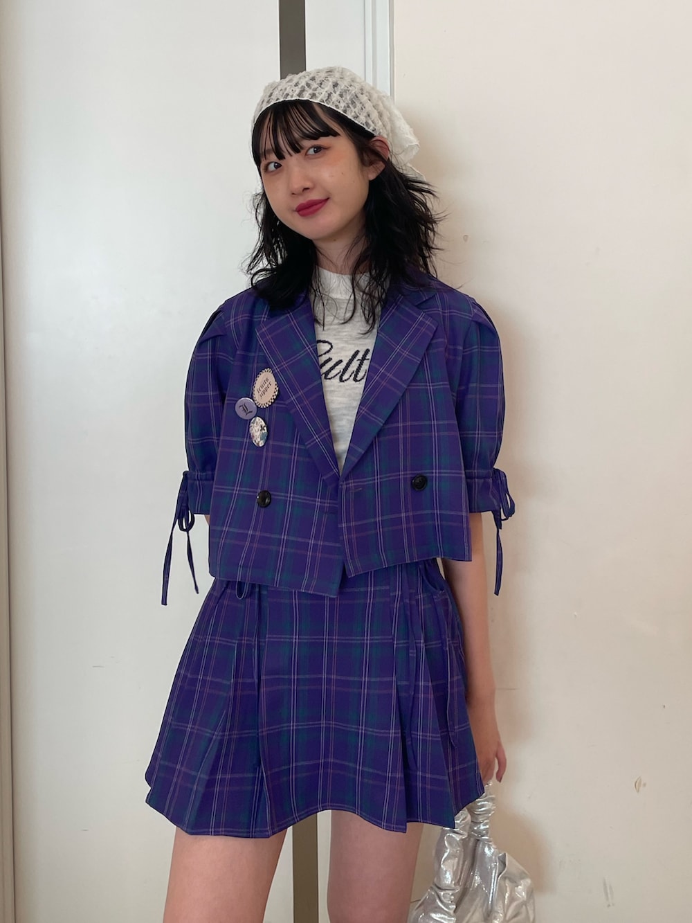 ホワイト系のニット/セーター、パープル系のテーラードジャケット、パープル系のスカートを着用したレディースの冬コーディネートの4枚目の写真