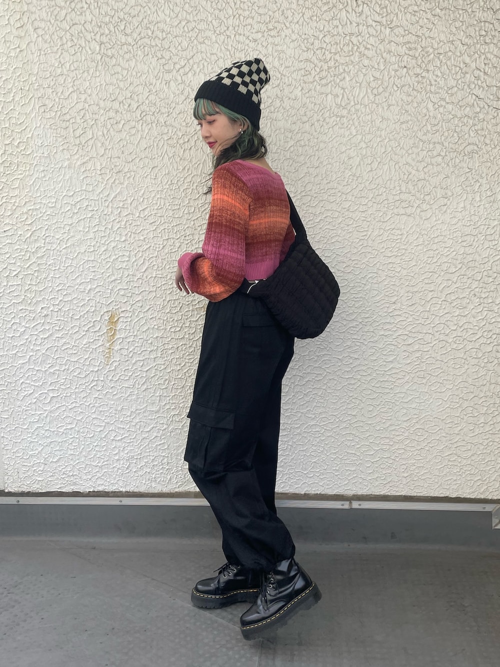 ブラック系のカーゴパンツ、ブラック系のハンドバッグ、ピンク系のカーディガン/ボレロを着用したレディースの秋コーディネートの2枚目の写真