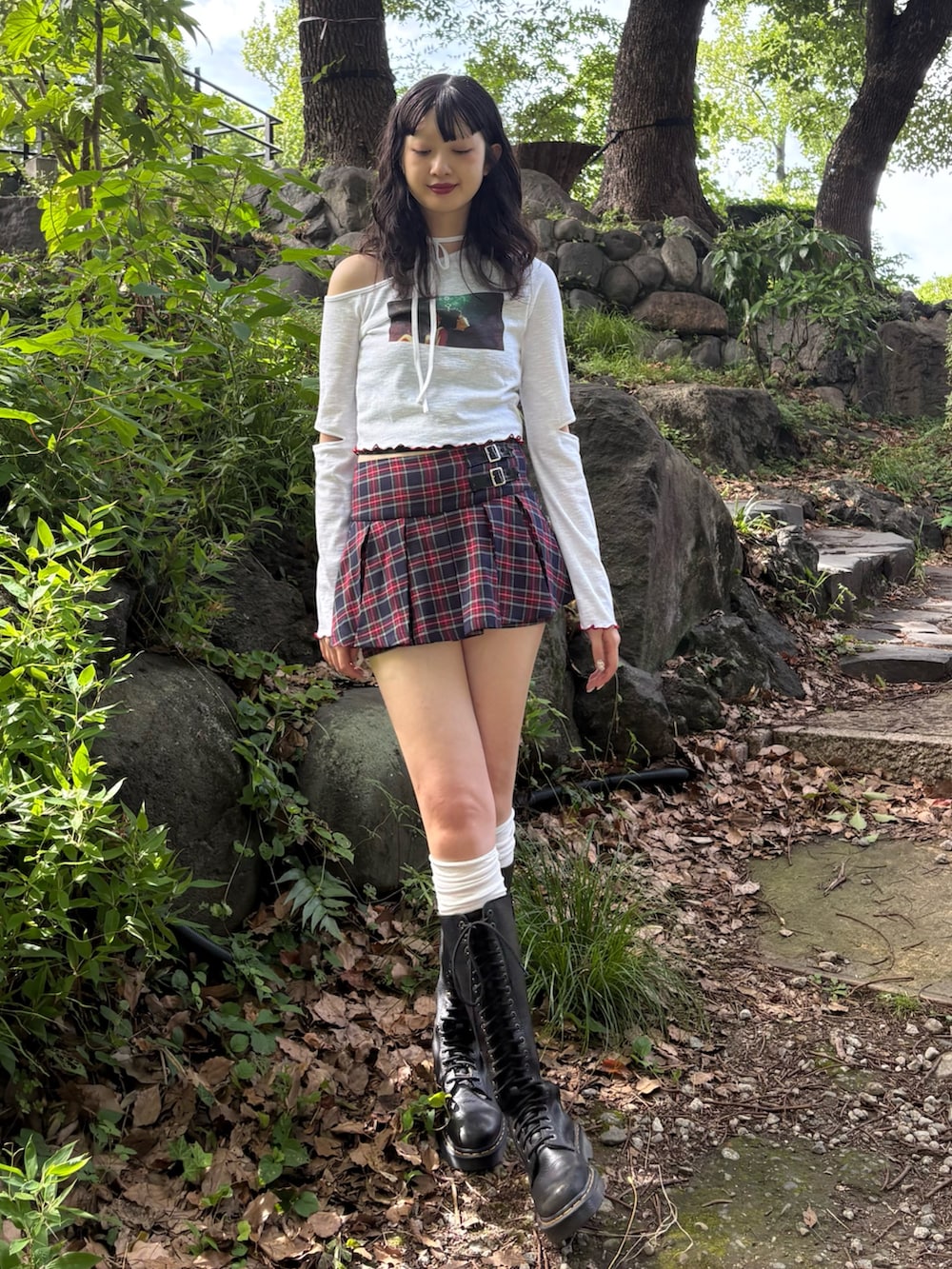 ホワイト系のTシャツ/カットソー、ブルー系のスカート、ブラック系のブーツを着用したレディースの夏コーディネートの2枚目の写真