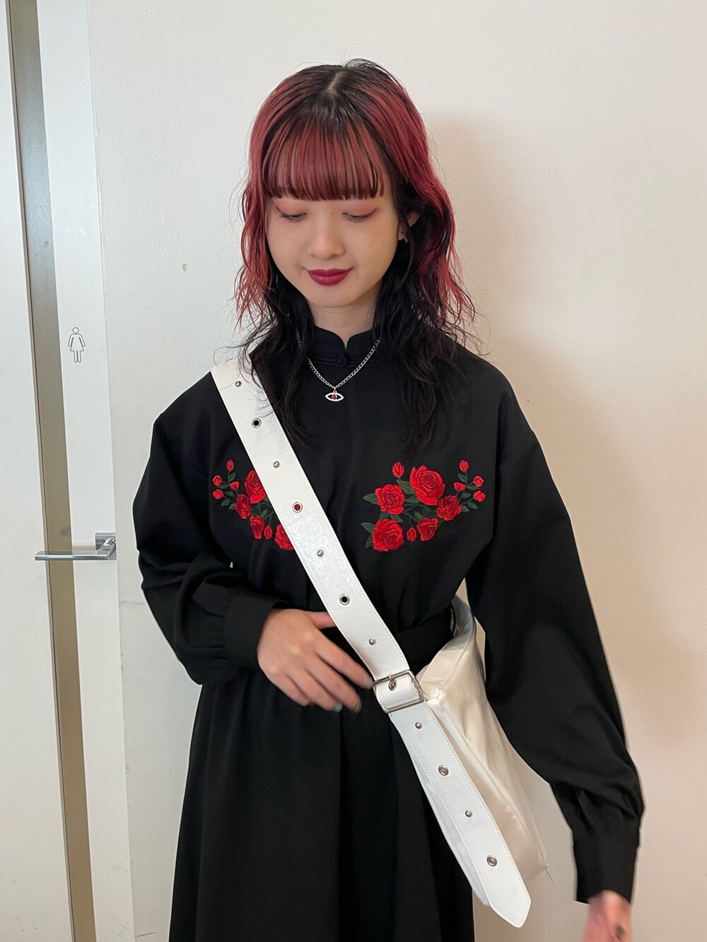 ホワイト系のショルダーバッグ、ブラック系のワンピース、ブラック系のブーツを着用したレディースの冬コーディネートの4枚目の写真