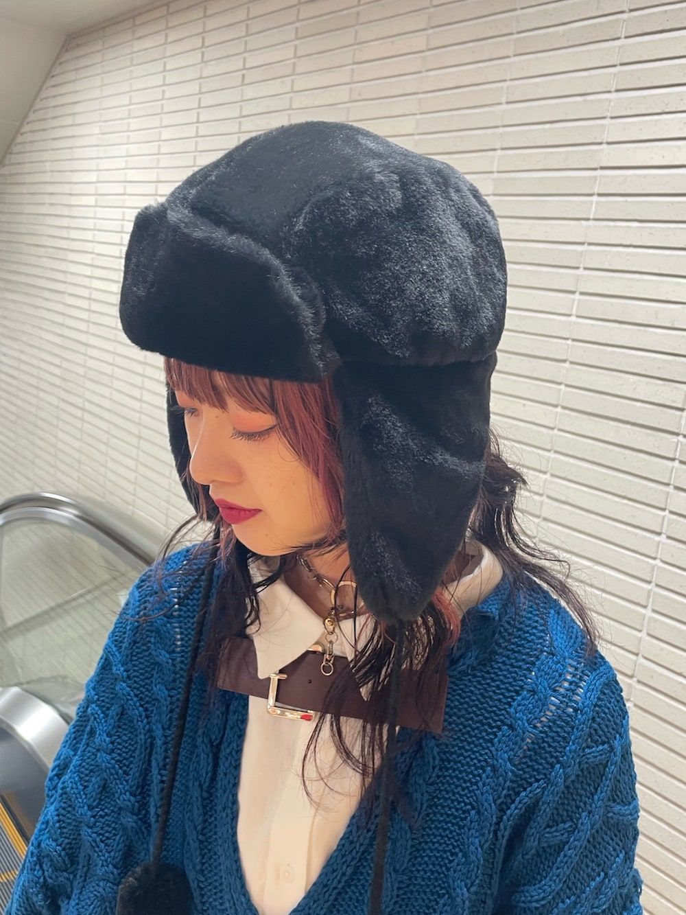 ブルー系のニット/セーター、ホワイト系のシャツ/ブラウス、ホワイト系のトートバッグを着用したレディースの冬コーディネートの9枚目の写真