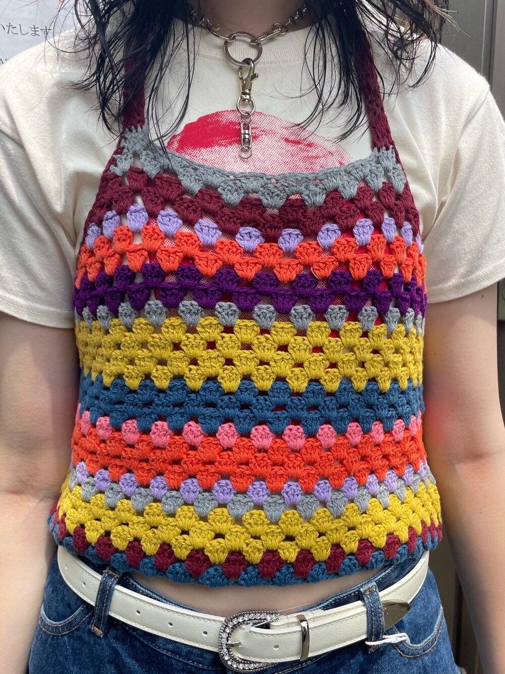 ホワイト系のTシャツ/カットソー、ブルー系のデニムパンツ、イエロー系のニット/セーターを着用したレディースの春コーディネートの5枚目の写真