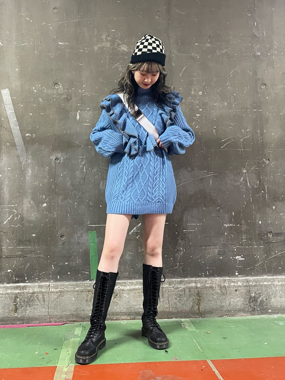 ブラック系のブーツ、ホワイト系のハンドバッグ、ブルー系のニット/セーターを着用したレディースの冬コーディネートの2枚目の写真