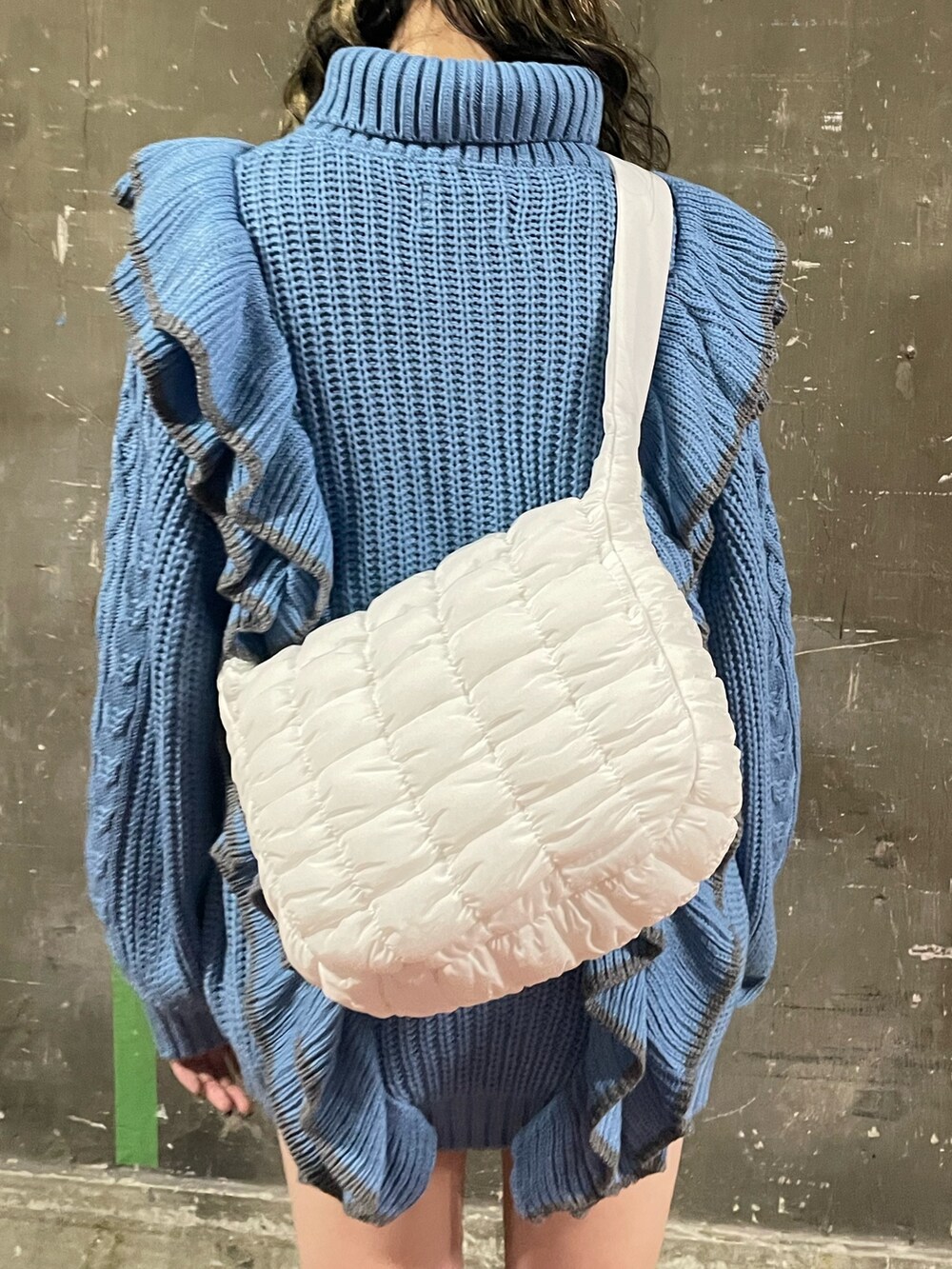 ブラック系のブーツ、ホワイト系のハンドバッグ、ブルー系のニット/セーターを着用したレディースの冬コーディネートの8枚目の写真