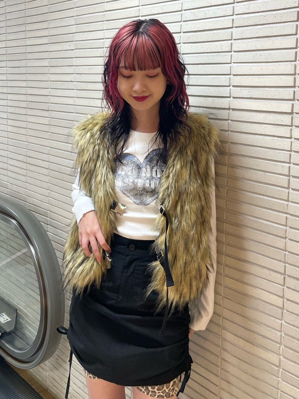 ベージュ系のベスト、ホワイト系のTシャツ/カットソー、ブラック系のスカートを着用したレディースの秋コーディネートの4枚目の写真