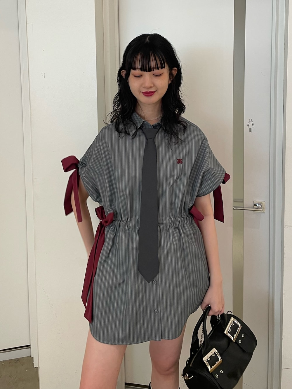 グレー系のシャツ/ブラウス、グレー系のネクタイ、ブラック系のボストンバッグを着用したレディースの夏コーディネートの4枚目の写真