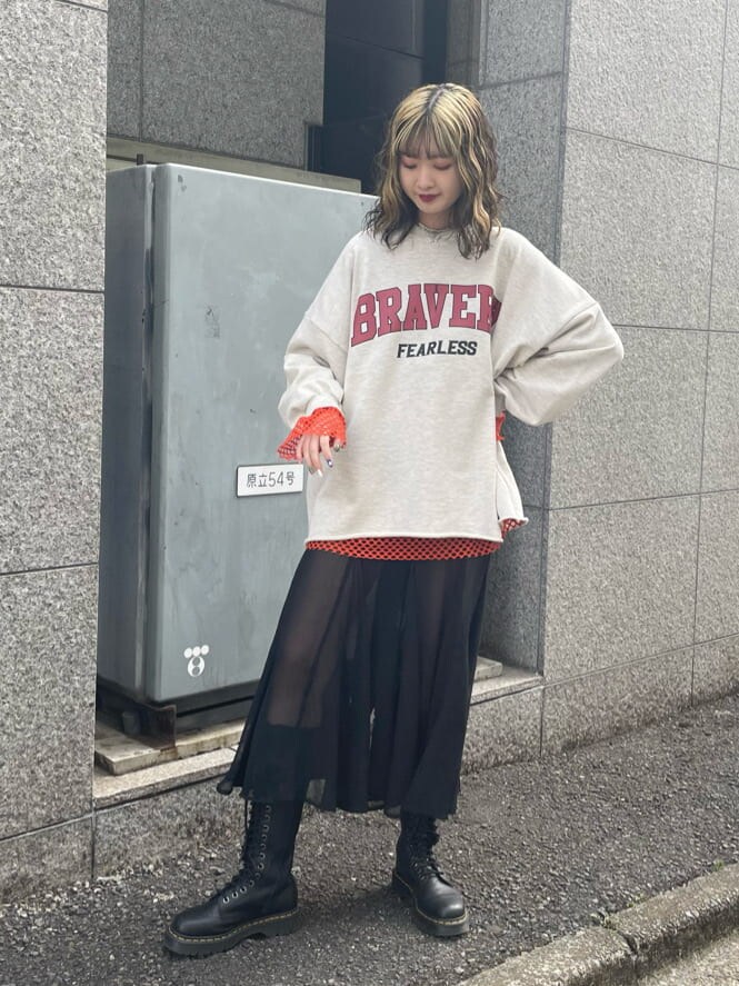 ブラック系のブーツ、ブラック系のスカート、オレンジ系のTシャツ/カットソーを着用したレディースの春コーディネートの2枚目の写真