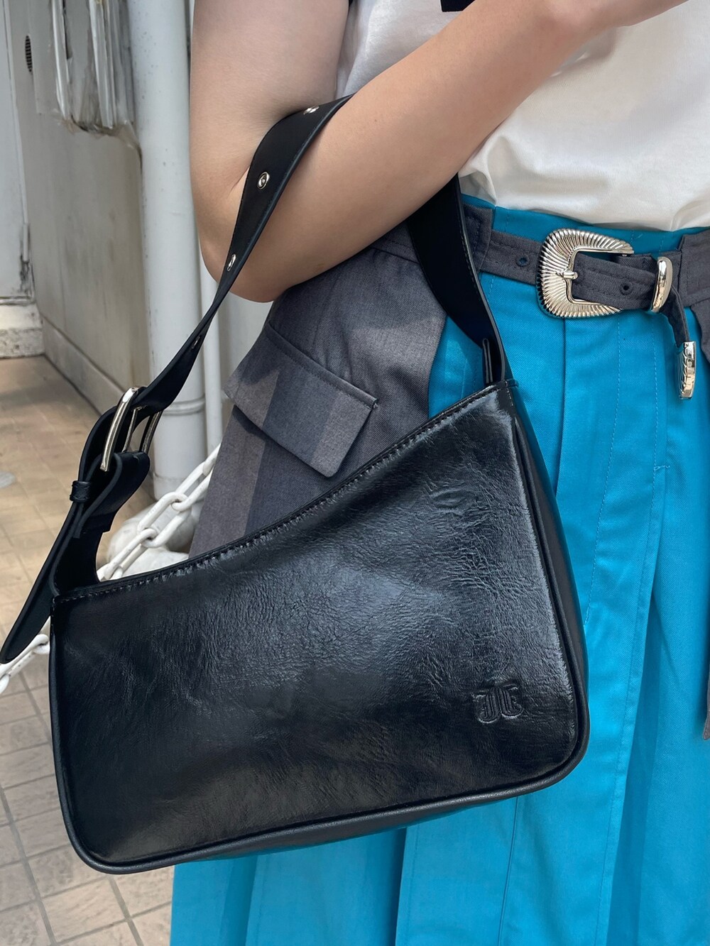 ホワイト系のTシャツ/カットソー、ブルー系のスカート、ブラック系のハンドバッグを着用したレディースの春コーディネートの5枚目の写真