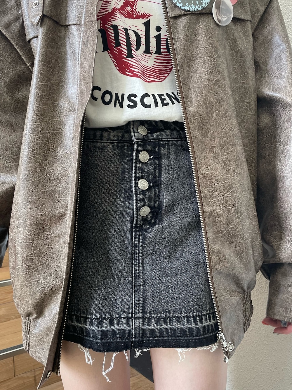 ブラック系のデニムパンツ、ブラウン系のブルゾン、ホワイト系のTシャツ/カットソーを着用したレディースの秋コーディネートの7枚目の写真