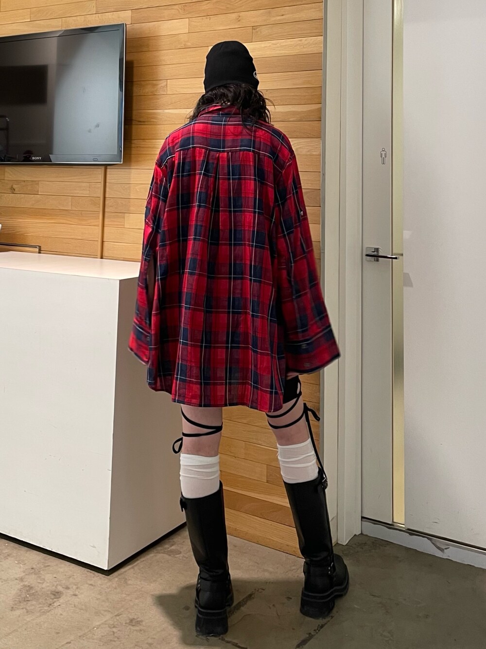 レッド系のシャツ/ブラウス、ブラック系のその他パンツ、ブラック系のブーツを着用したレディースの春コーディネートの3枚目の写真