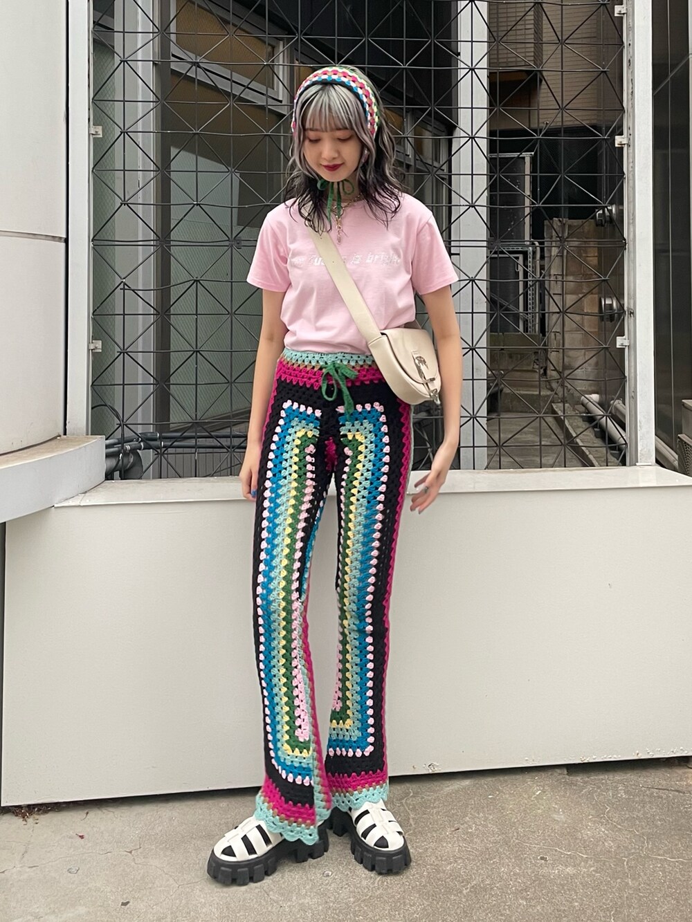 ピンク系のTシャツ/カットソー、ブラック系のその他パンツ、ホワイト系のショルダーバッグを着用したレディースの春コーディネートの2枚目の写真