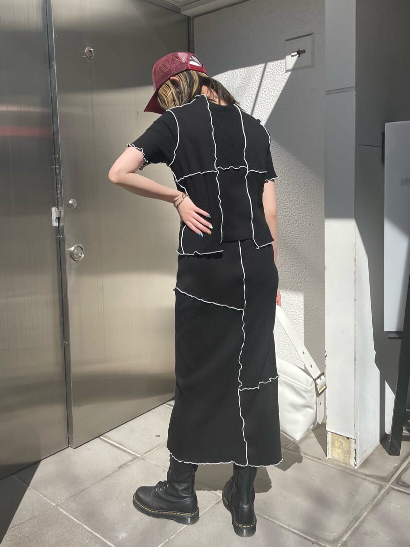 ブラック系のスカート、ブラック系のTシャツ/カットソー、シルバー系のネックレスを着用したレディースの春コーディネートの3枚目の写真