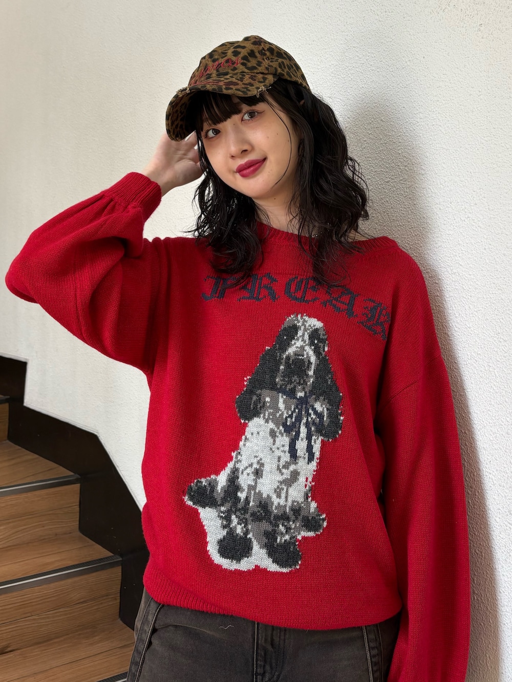 レッド系のニット/セーター、ブラック系のデニムパンツ、ブラック系のショルダーバッグを着用したレディースの秋コーディネートの3枚目の写真