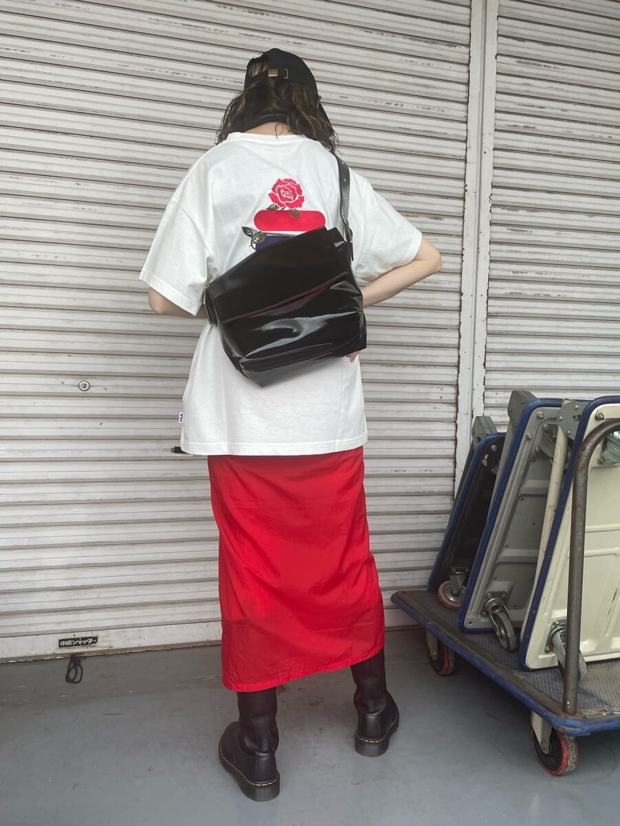 ブラック系のブーツ、ホワイト系のTシャツ/カットソー、ブラック系のハンドバッグを着用したレディースの春コーディネートの3枚目の写真