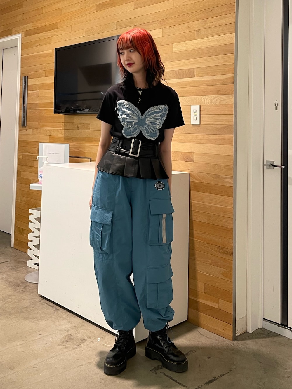ブラック系のTシャツ/カットソー、ブルー系のカーゴパンツ、ブラック系のその他シューズを着用したレディースの春コーディネートの2枚目の写真