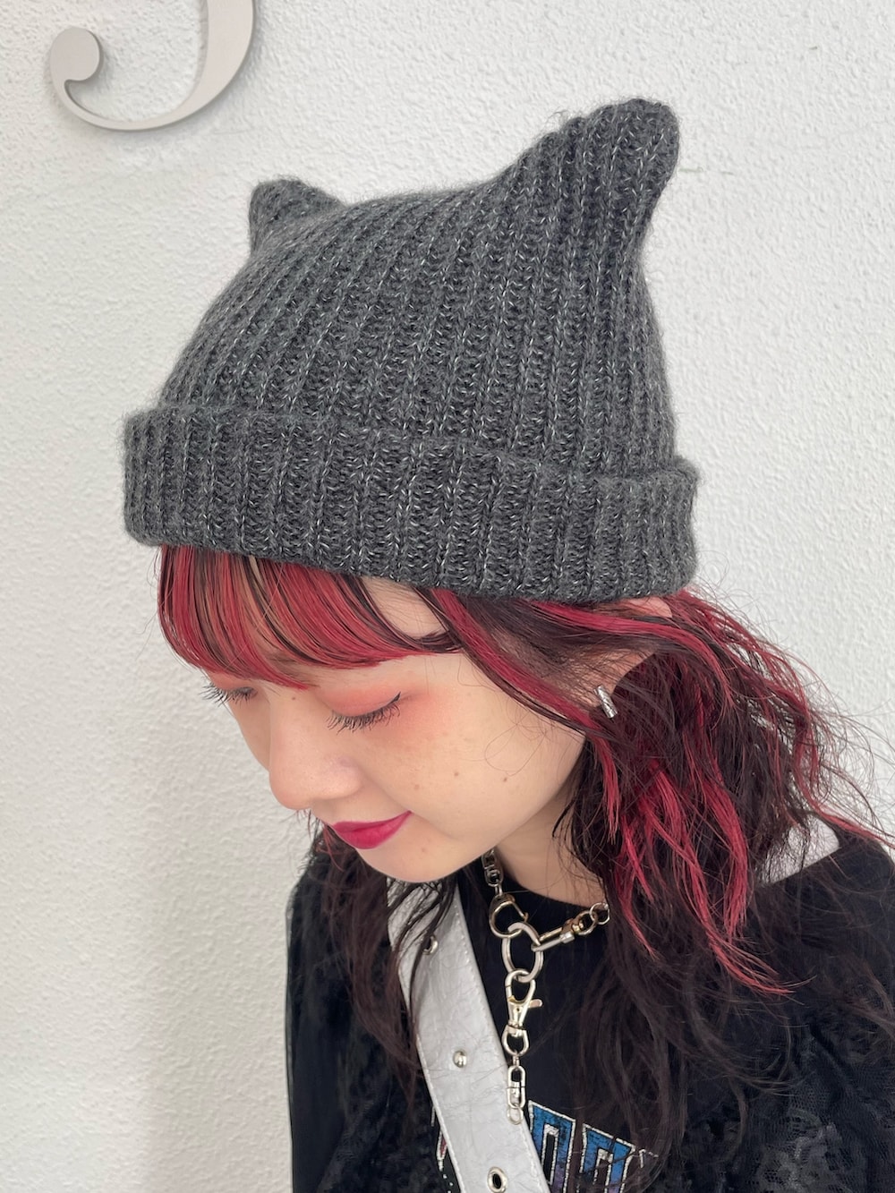 ブラック系のワンピース、レッド系のスカート、シルバー系のショルダーバッグを着用したレディースの冬コーディネートの8枚目の写真