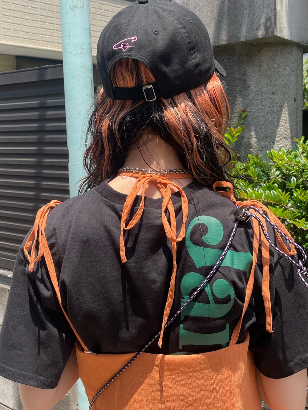 ブラック系のTシャツ/カットソー、オレンジ系のワンピース、ブラック系のショルダーバッグを着用したレディースの夏コーディネートの7枚目の写真