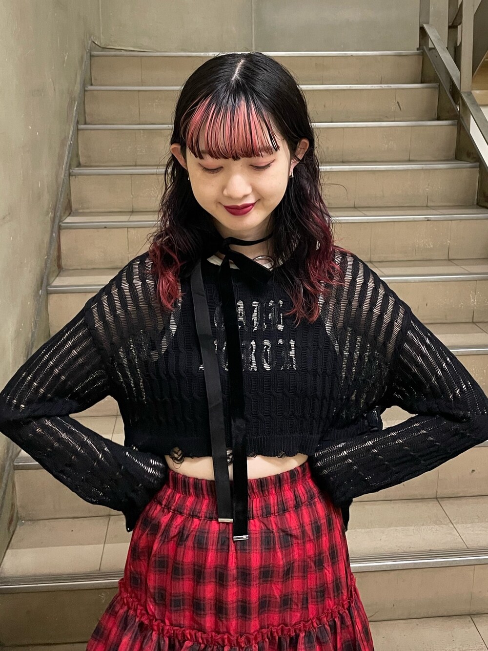 ブラック系のニット/セーター、ブラック系のタンクトップ、レッド系のスカートを着用したレディースの春コーディネートの4枚目の写真