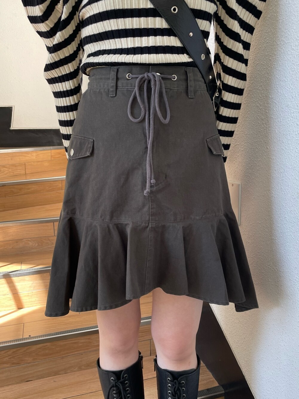 ホワイト系のニット/セーター、ブラック系のブーツ、ブラック系のスカートを着用したレディースの冬コーディネートの7枚目の写真