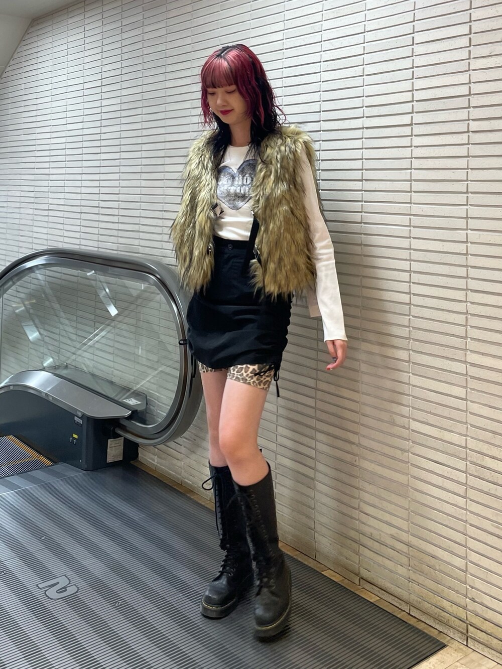 ベージュ系のベスト、ホワイト系のTシャツ/カットソー、ブラック系のスカートを着用したレディースの秋コーディネートの2枚目の写真