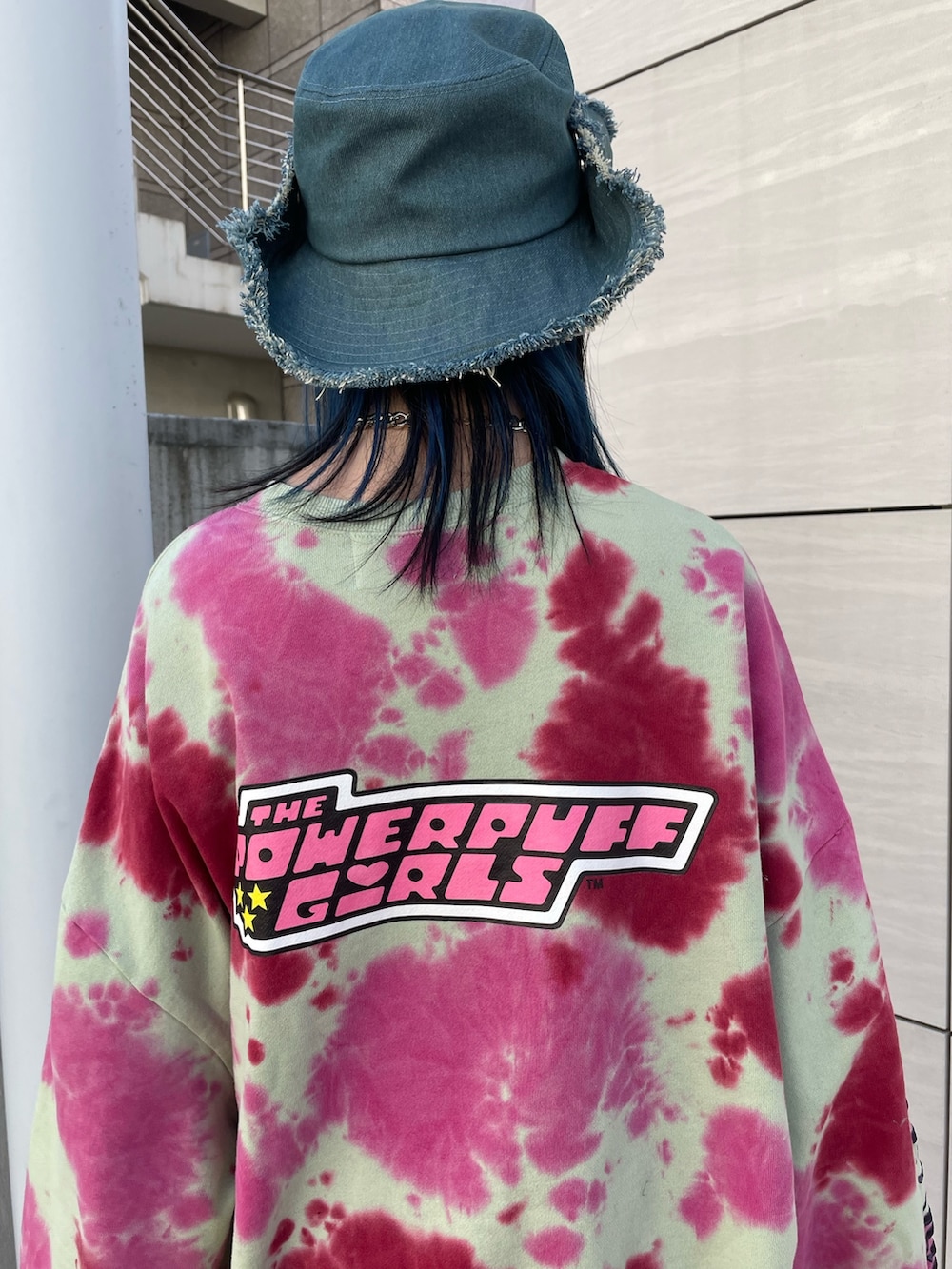 グリーン系のスウェット、ホワイト系のワンピース、ブラック系のブーツを着用したレディースの冬コーディネートの6枚目の写真