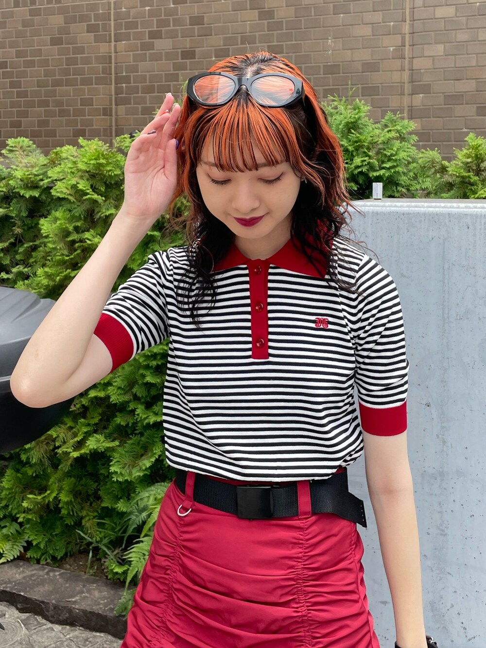 ホワイト系のニット/セーター、ブラック系のボストンバッグ、レッド系のスカートを着用したレディースの夏コーディネートの4枚目の写真