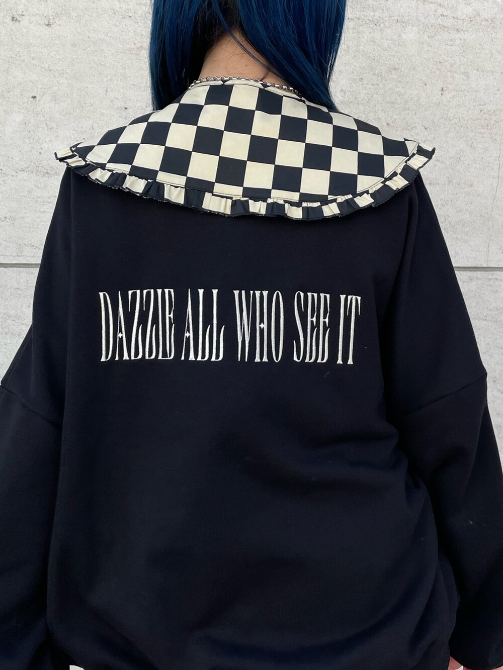 ブラック系のスウェット、レッド系のジャンパースカート、ブラック系のブーツを着用したレディースの冬コーディネートの7枚目の写真