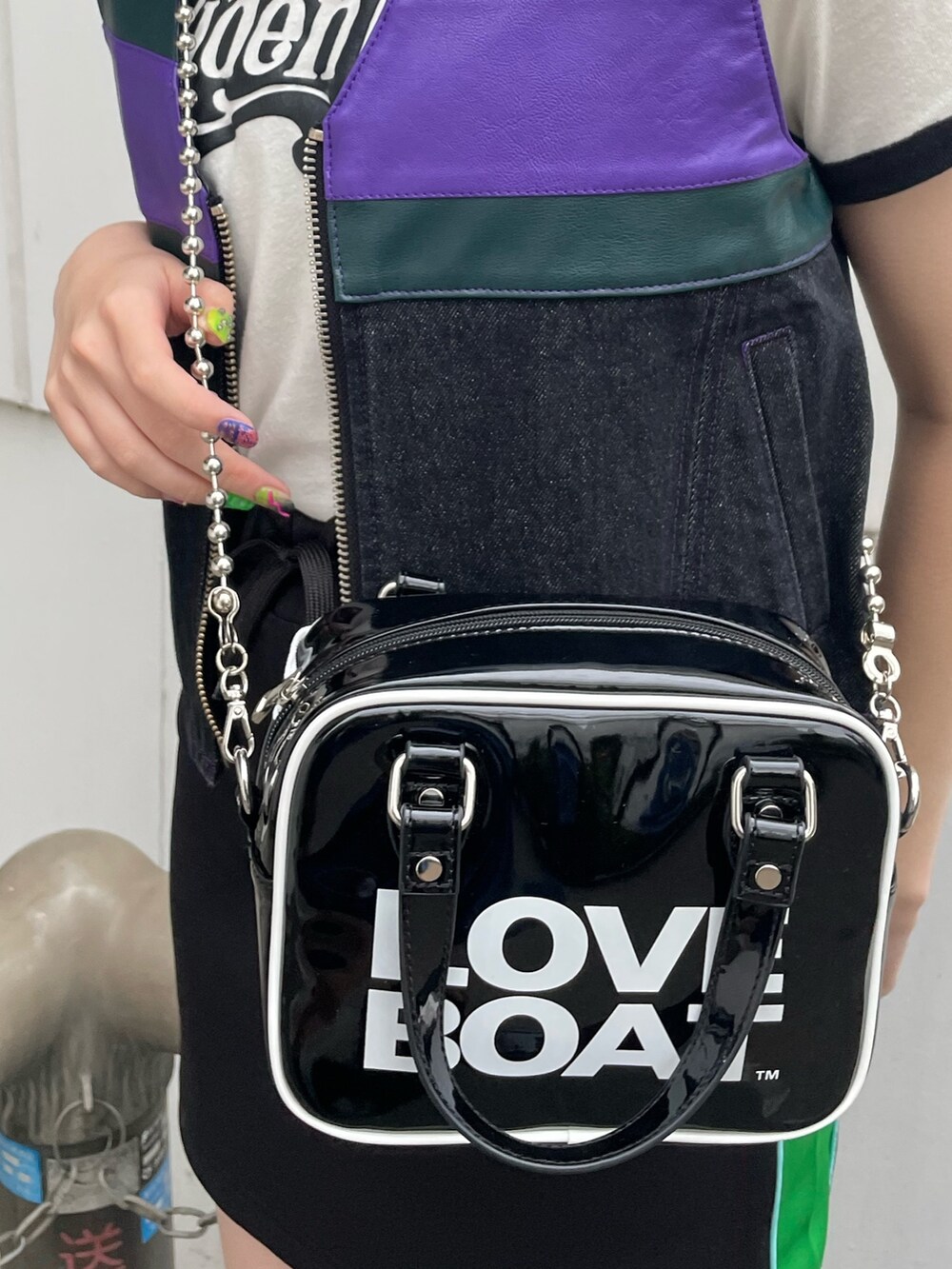 ブラック系のスカート、ブラック系のベスト、ブラック系のボストンバッグを着用したレディースの春コーディネートの6枚目の写真