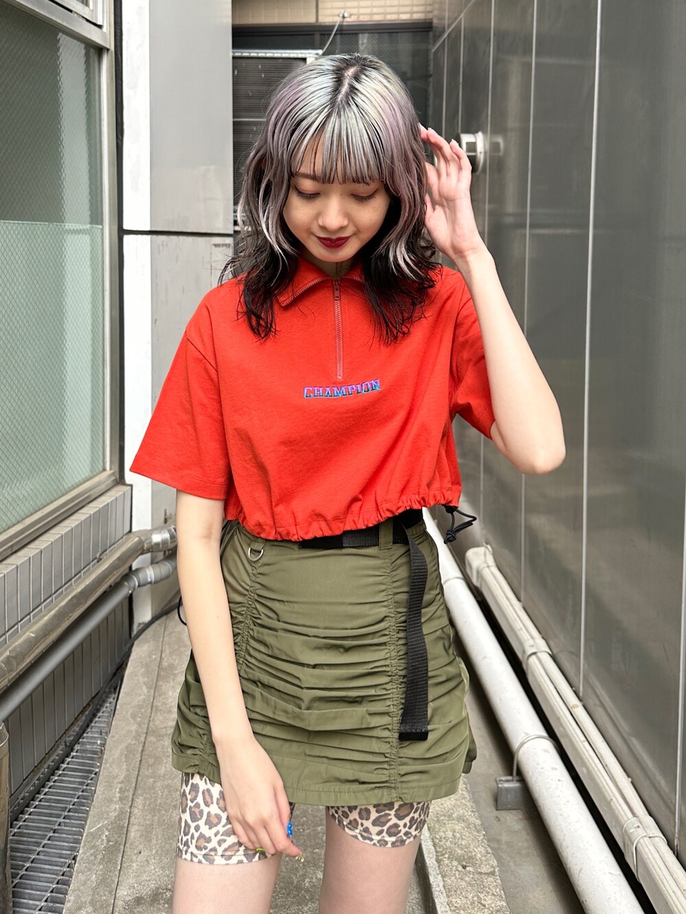 レッド系のTシャツ/カットソー、グリーン系のスカート、ベージュ系のその他パンツを着用したレディースの春コーディネートの4枚目の写真