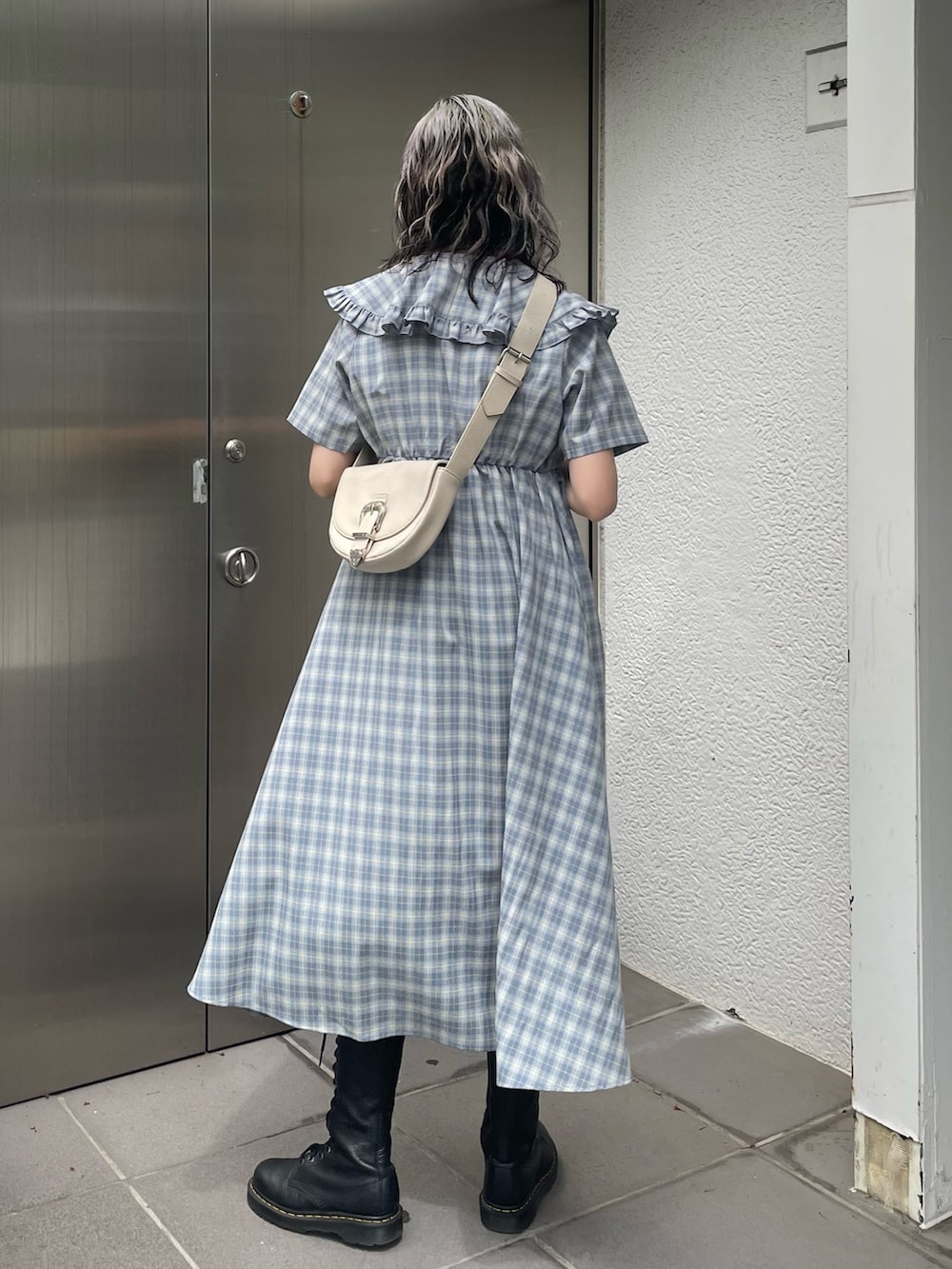 ブルー系のワンピース、ブラック系のデニムパンツ、ホワイト系のショルダーバッグを着用したレディースの春コーディネートの3枚目の写真