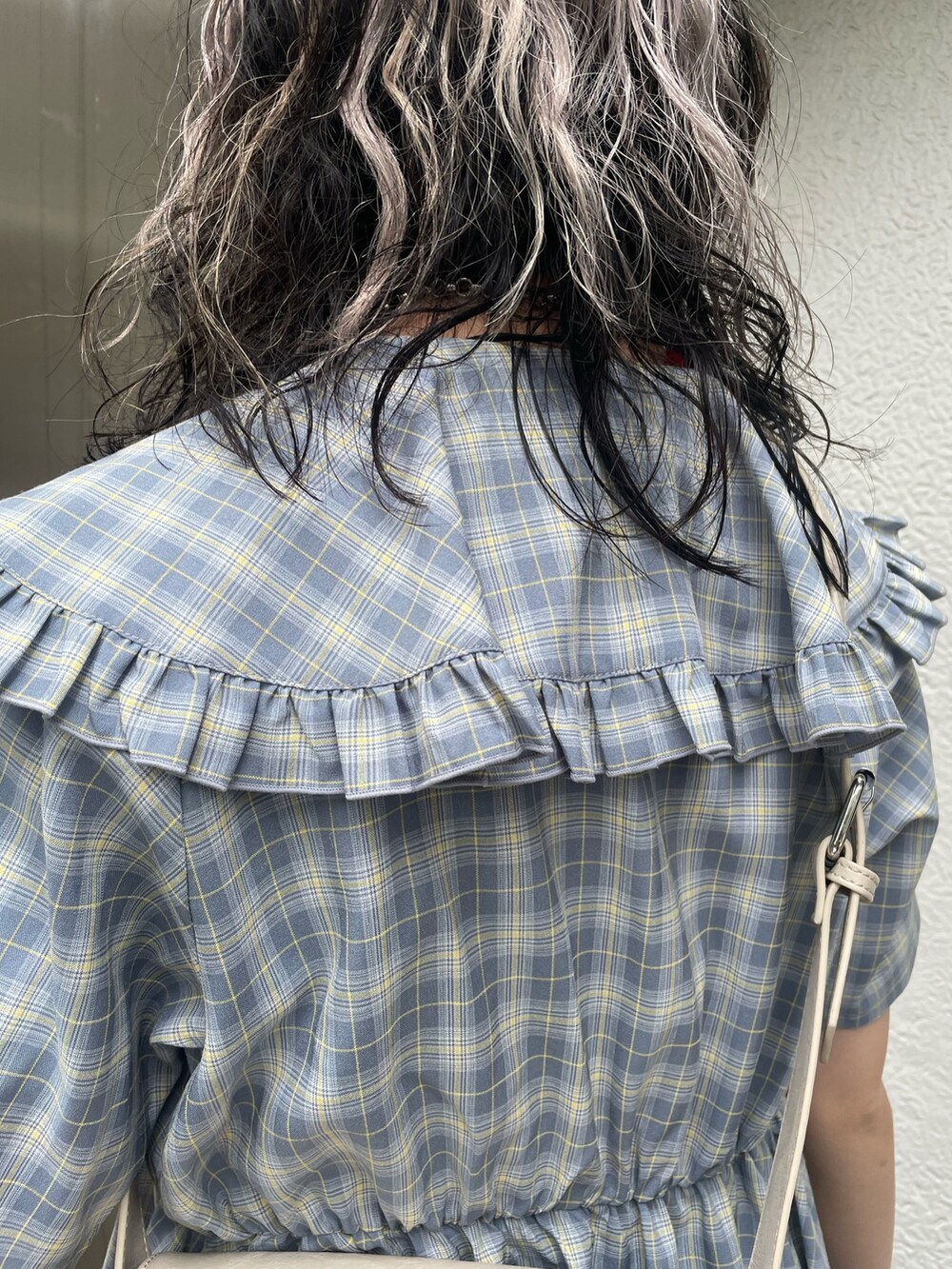 ブルー系のワンピース、ブラック系のデニムパンツ、ホワイト系のショルダーバッグを着用したレディースの春コーディネートの8枚目の写真