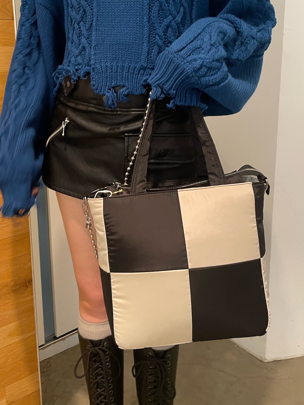 ブラック系のその他パンツ、ブルー系のニット/セーター、ブラック系のブーツを着用したレディースの冬コーディネートの8枚目の写真