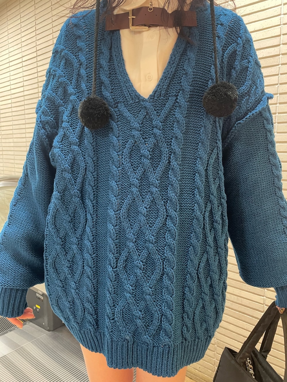 ブルー系のニット/セーター、ホワイト系のシャツ/ブラウス、ホワイト系のトートバッグを着用したレディースの冬コーディネートの6枚目の写真