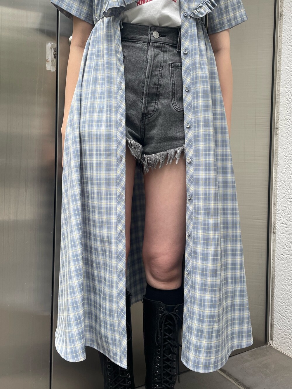 ブルー系のワンピース、ブラック系のデニムパンツ、ホワイト系のショルダーバッグを着用したレディースの春コーディネートの7枚目の写真