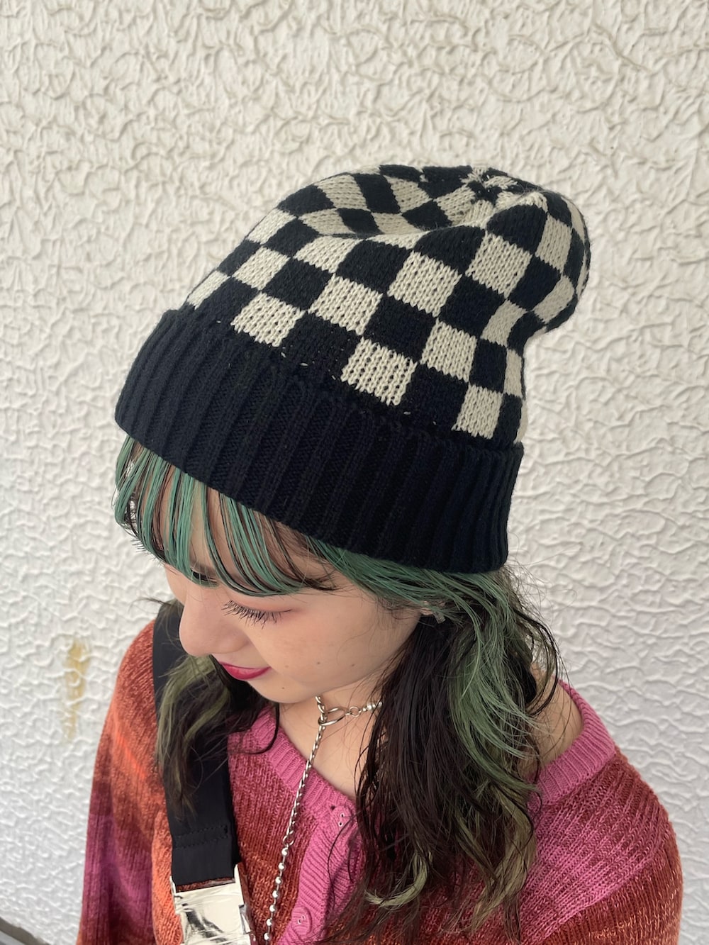 ブラック系のカーゴパンツ、ブラック系のハンドバッグ、ピンク系のカーディガン/ボレロを着用したレディースの秋コーディネートの7枚目の写真