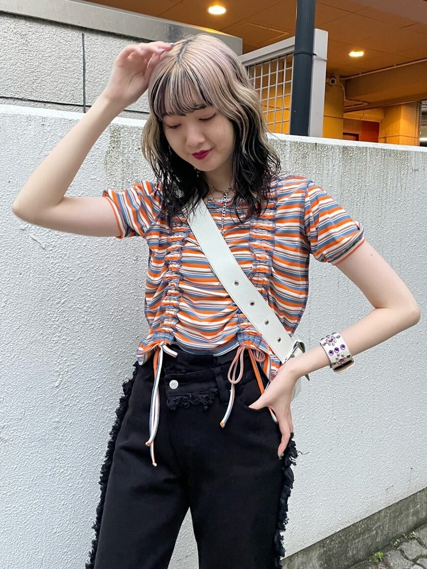 ブラック系のブーツ、ホワイト系のハンドバッグ、ブラック系のデニムパンツを着用したレディースの夏コーディネートの4枚目の写真