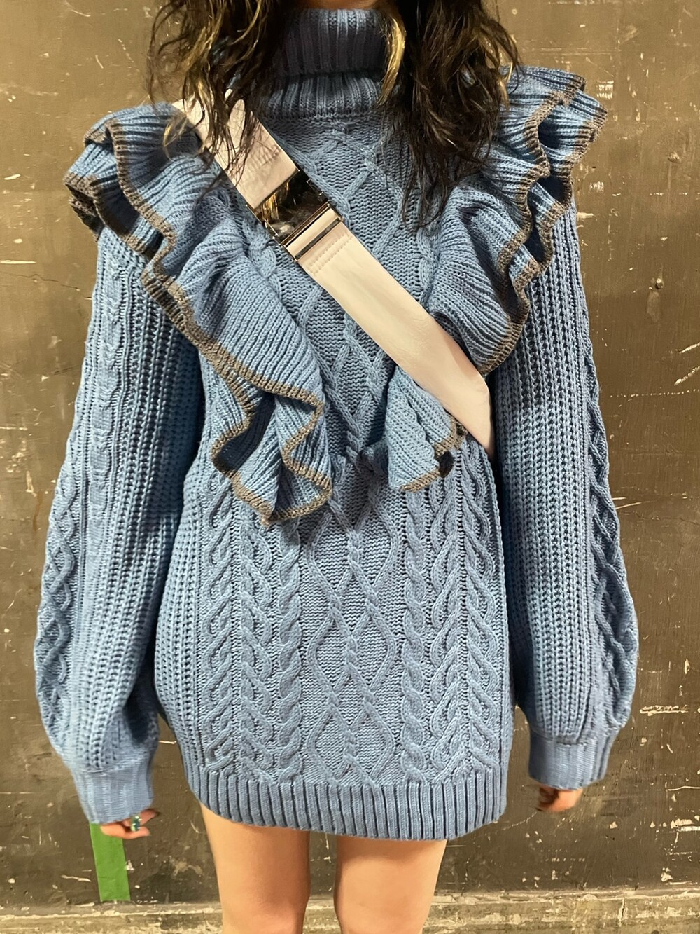 ブラック系のブーツ、ホワイト系のハンドバッグ、ブルー系のニット/セーターを着用したレディースの冬コーディネートの7枚目の写真