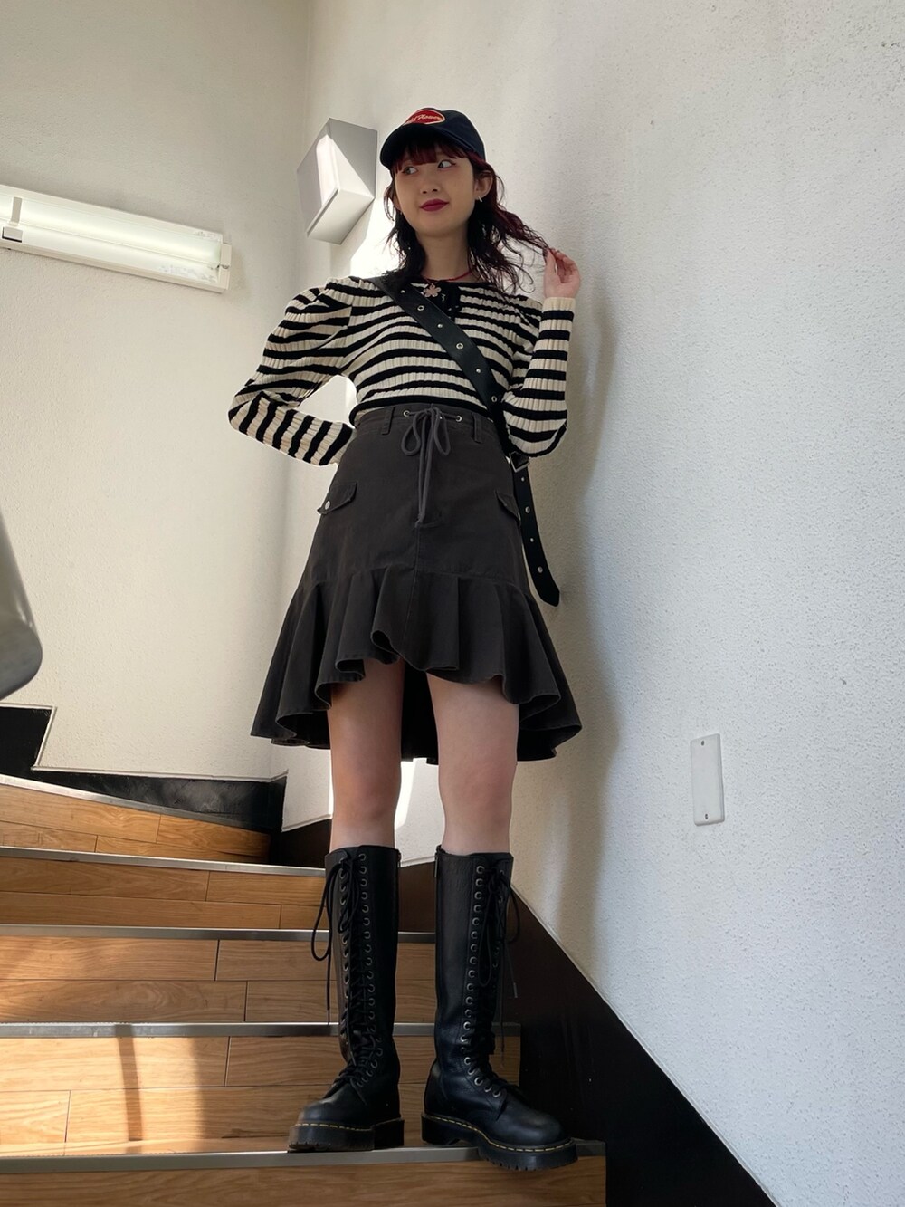 ホワイト系のニット/セーター、ブラック系のブーツ、ブラック系のスカートを着用したレディースの冬コーディネートの2枚目の写真