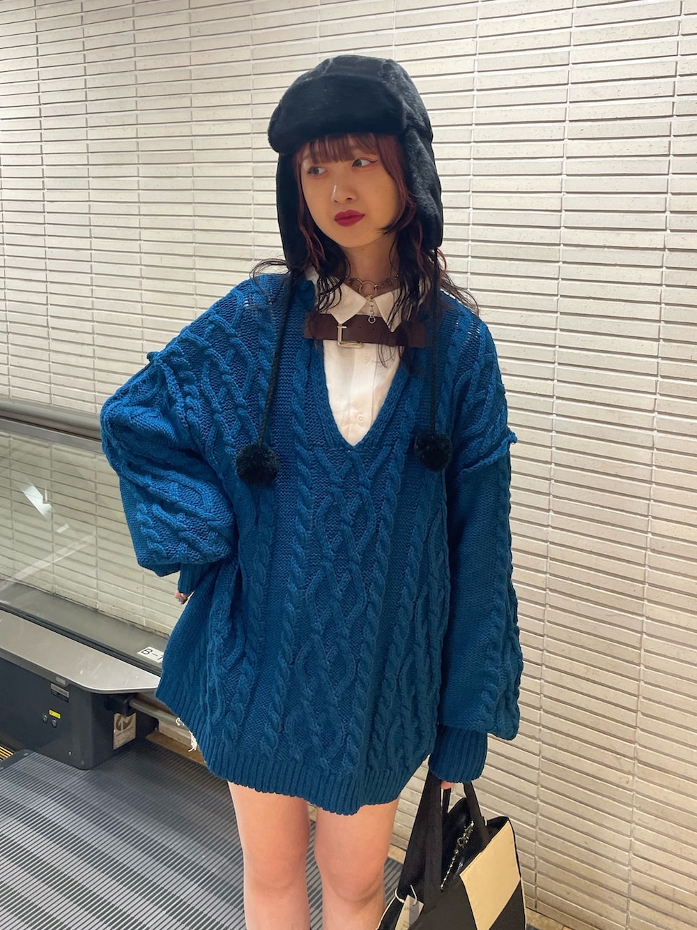 ブルー系のニット/セーター、ホワイト系のシャツ/ブラウス、ホワイト系のトートバッグを着用したレディースの冬コーディネートの3枚目の写真