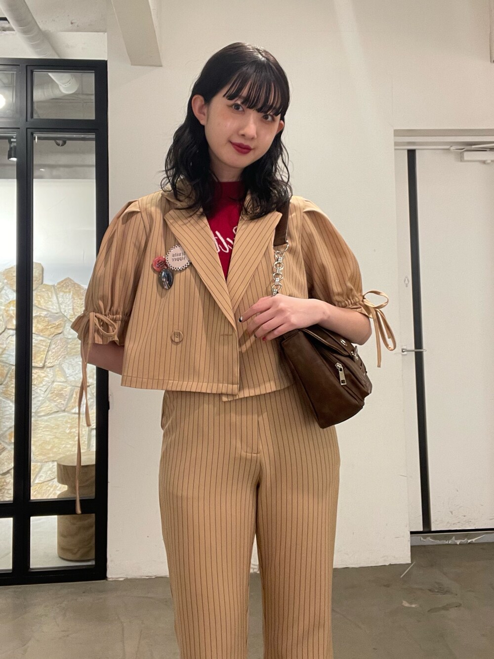 ベージュ系のその他パンツ、ベージュ系のテーラードジャケット、レッド系のニット/セーターを着用したレディースの冬コーディネートの3枚目の写真