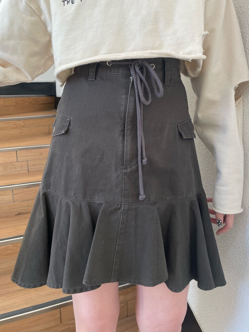 ホワイト系のパーカー、レッド系のブーツ、ブラック系のスカートを着用したレディースの春コーディネートの7枚目の写真