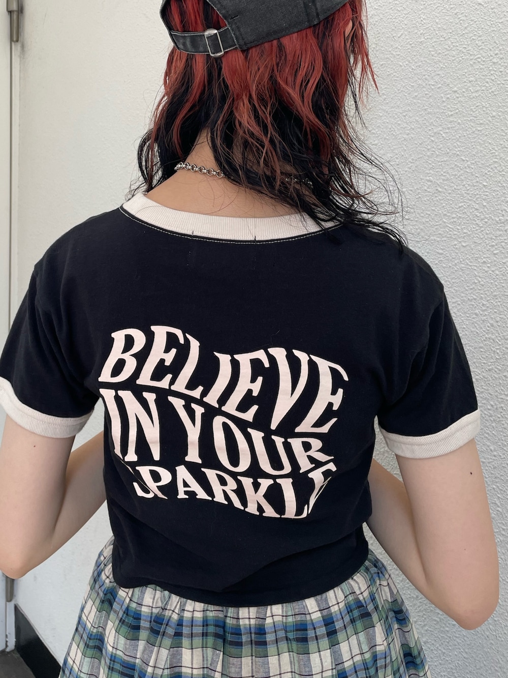 グリーン系のスカート、ブラック系のTシャツ/カットソー、ホワイト系のサンダルを着用したレディースの夏コーディネートの7枚目の写真