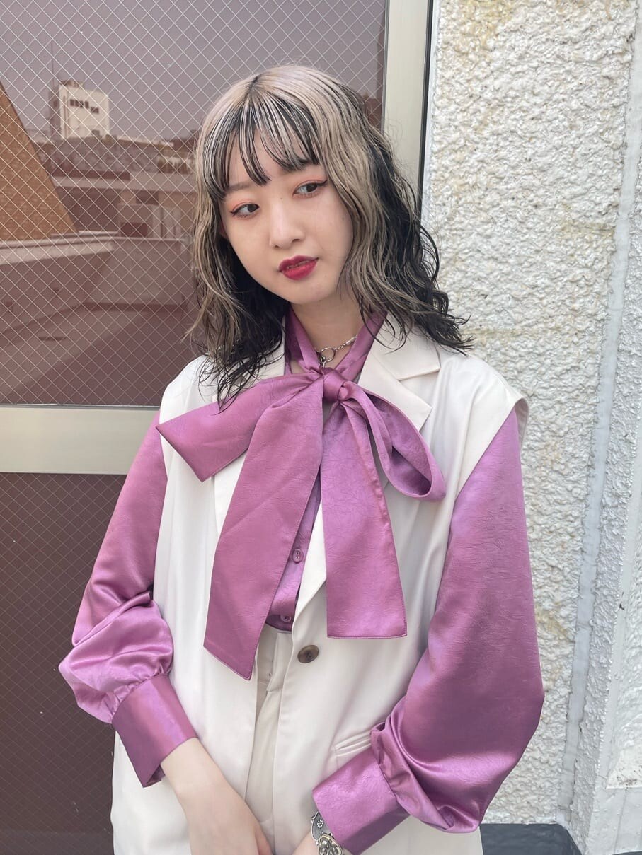 ピンク系のシャツ/ブラウス、ブラック系のブーツ、ホワイト系のベストを着用したレディースの春コーディネートの6枚目の写真