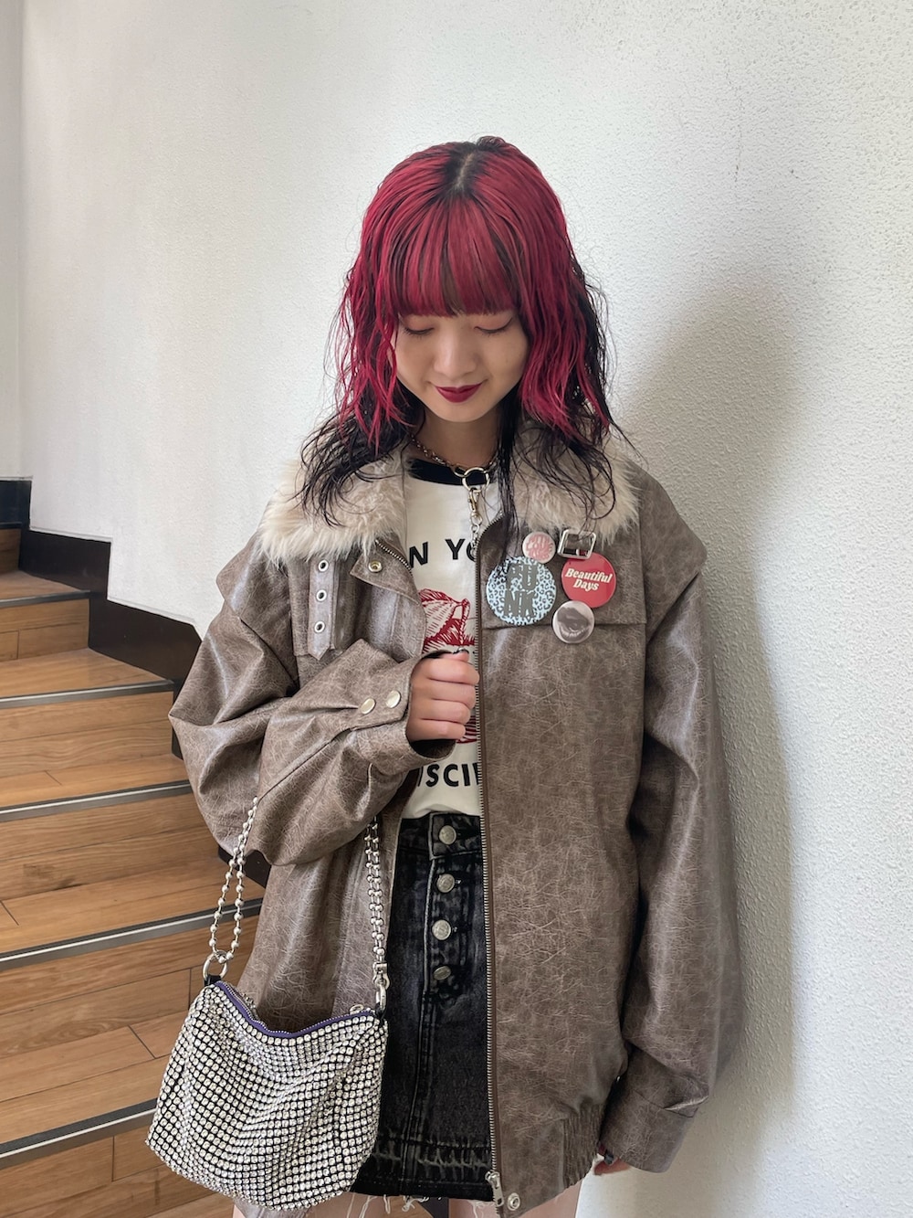 ブラック系のデニムパンツ、ブラウン系のブルゾン、ホワイト系のTシャツ/カットソーを着用したレディースの秋コーディネートの4枚目の写真