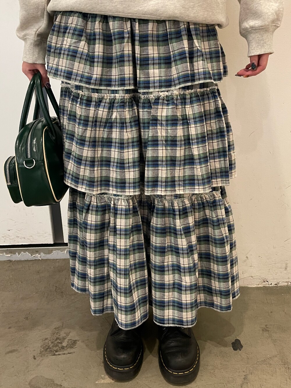 グレー系のスウェット、グリーン系のスカート、グリーン系のボストンバッグを着用したレディースの夏コーディネートの7枚目の写真