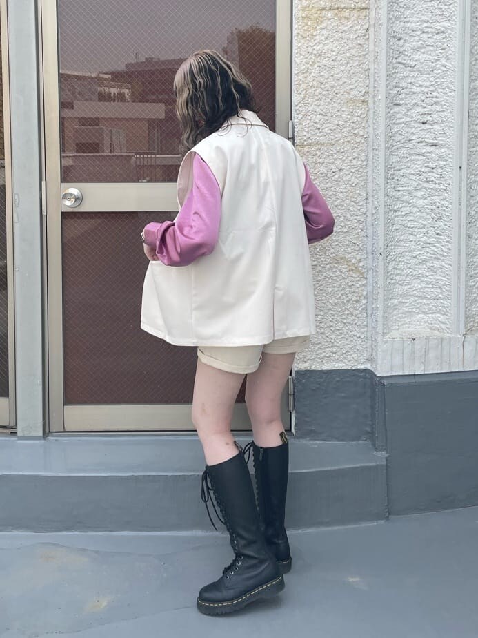 ピンク系のシャツ/ブラウス、ブラック系のブーツ、ホワイト系のベストを着用したレディースの春コーディネートの4枚目の写真