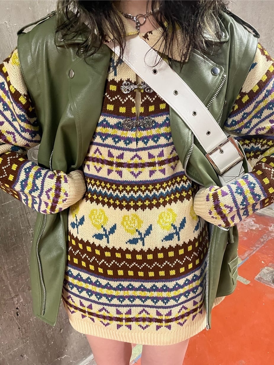 ブラック系のブーツ、ホワイト系のハンドバッグ、グリーン系のライダースジャケットを着用したレディースの秋コーディネートの6枚目の写真