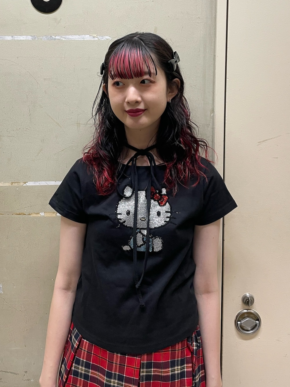 ブラック系のTシャツ/カットソー、レッド系のスカート、ブラック系のブーツを着用したレディースの春コーディネートの5枚目の写真
